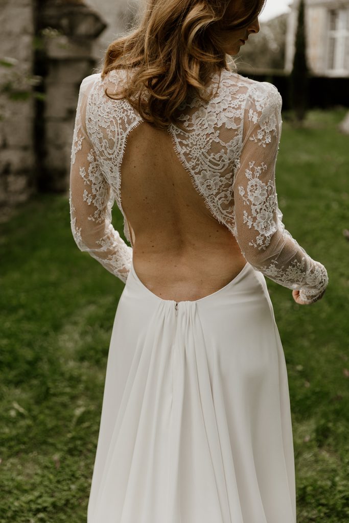 detail du dos nu plongeant en V inversé en dentelle de calais et sa jupe froncée en crepe de soie