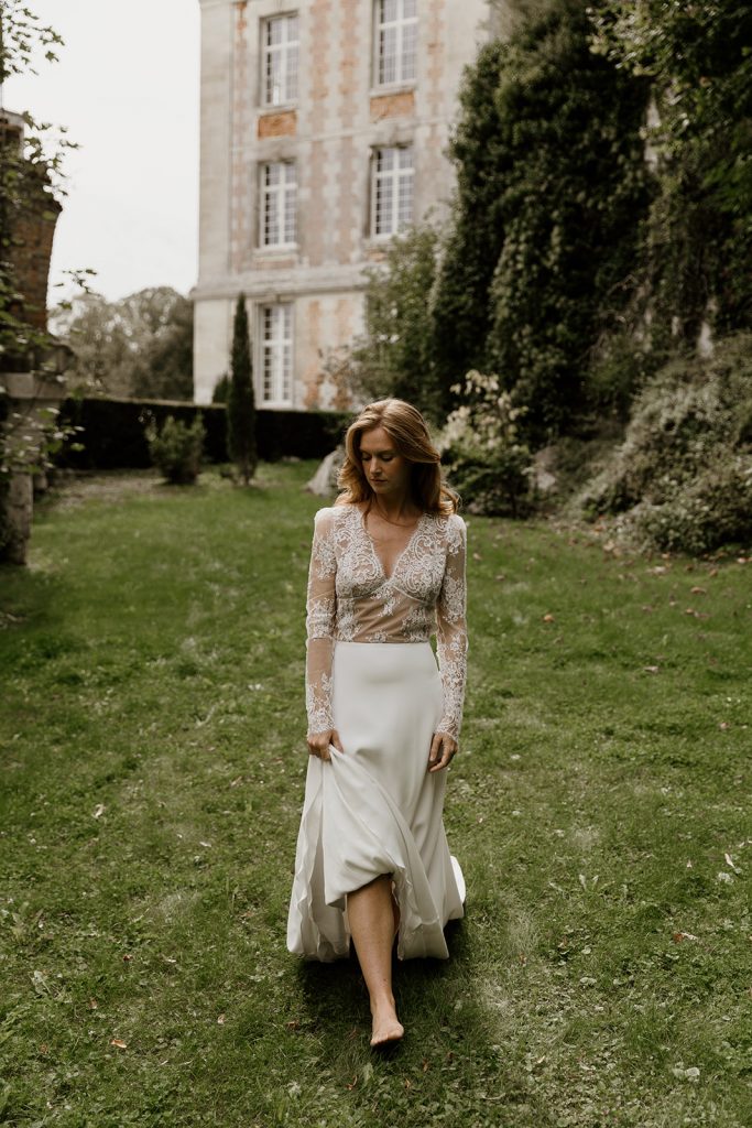 robe de mariée fluide élégante col v manches longues en dentelle de calais et bas évasé en crepe