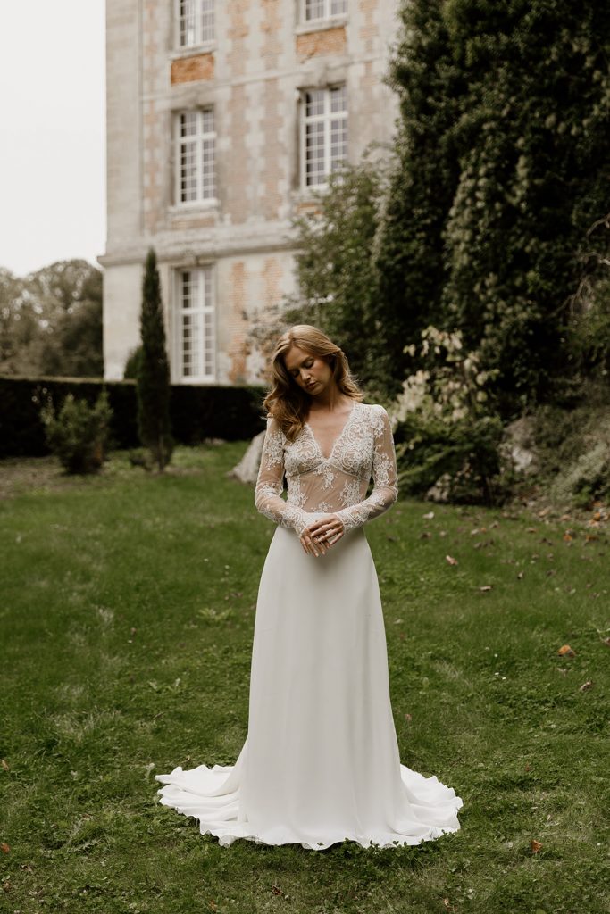 robe de mariée fluide élégante col v manches longues en dentelle de calais et bas évasé en crepe
