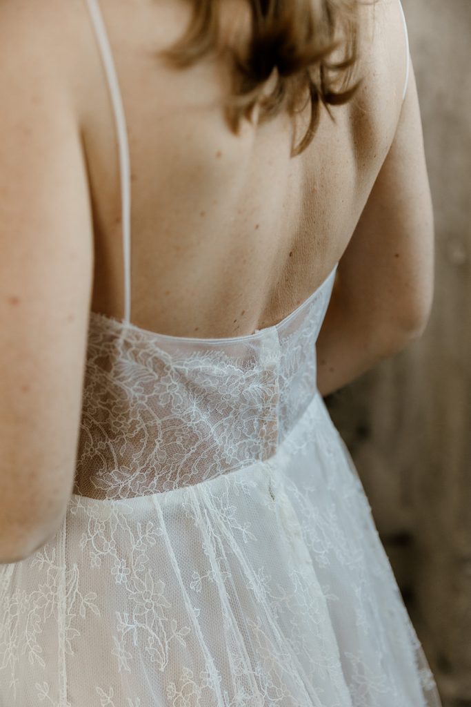 detail du dos nu de la robe de mariée Esmée en dentelle de chantilly fond nude